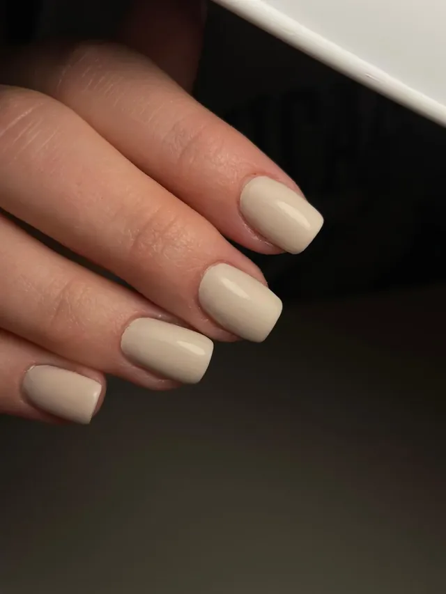 Korte, glanzende nagels in een beige tint.